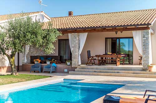 ein privater Swimmingpool, Olivenhain, massiver Tisch, eine Eckgarnitur unter der überdachten Terrasse, ein Haus mit dem Swimmingpool für die Erholung, Mittelistrien